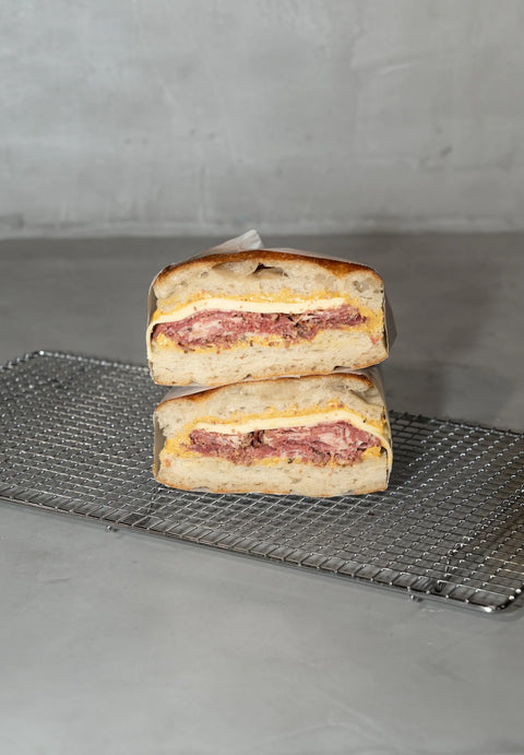Focaccia sandwich de masa madre de pastrami, salsa holandesa y queso gouda